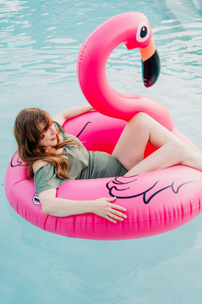 poolside maternity photoshoot in flower mound texas with blow up flamingo